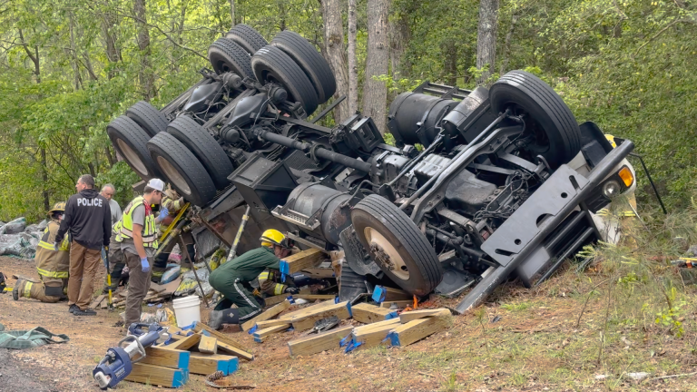 Rescuers work to free driver of overturned semi-truck | Photo: Patrick Priest