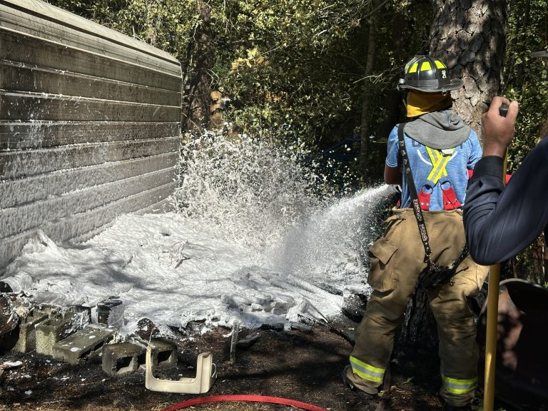 Outside fire spreads to woods, endangers structures