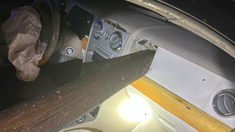 Car crashes through wood fence, dash impaled by piece of wood