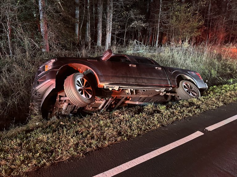 Truck tips into ditch while pulling over for emergency responder